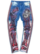 Load image into Gallery viewer, Blue jeans with red skeleton design and 'J' logo on a black background