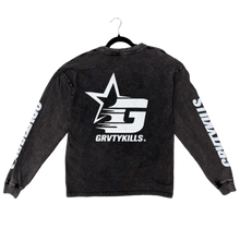 Load image into Gallery viewer, A black washed long-sleeve shirt with a large white star and 'GRVTYKILLS' logo on the back, laid flat on a textured brown carpet with a hanger. Green toe socks are visible at the bottom of the frame.