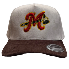 Load image into Gallery viewer, A baseball cap with a white structured crown, a dark brown visor, and a large embroidered red and yellow 'M' logo on the front, resting on a carpeted floor in a retail store.