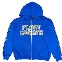 Load image into Gallery viewer, A bright blue zip-up hoodie laid flat on a carpeted floor. The front has the words "PLANT GROATH" in a white outlined graphic with green leafy details, and the sleeves have small green and black leaf motifs running down the sides.