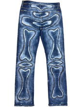 Load image into Gallery viewer, Blue jeans with bone patterns on a beige carpet
