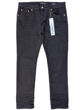 Load image into Gallery viewer, Black pants with a brand label on a gray surface
