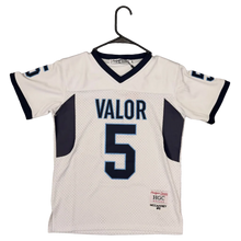 Load image into Gallery viewer, A white athletic jersey with navy blue trim and the name 'VALOR' and number '5' on the back, hanging on a black hanger over a brown carpet. A green and white shoe is partially visible at the bottom.
