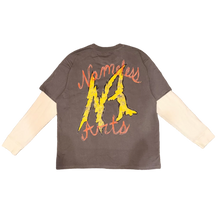 Load image into Gallery viewer, A dark gray t-shirt with a yellow and orange graphic on the back, layered over a cream long-sleeve shirt, laid flat on a brown carpet. A person's feet in fuzzy slippers are visible at the bottom of the frame.

