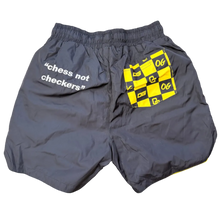 Load image into Gallery viewer, Gray shorts with a yellow and black pattern on the back, laid flat on a textured surface.
